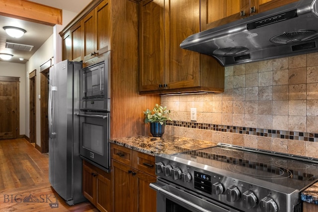2497 Northview, Bozeman, MT 59715 - kitchen featuring black appliances, exhaust hood, decorative backsplash, and brown cabinets