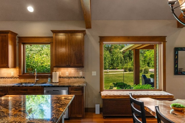 2497 Northview, Bozeman, MT 59715 - kitchen with backsplash, dark stone counters, beam ceiling, wood finished floors, and brown cabinetry