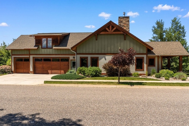2497 Northview, Bozeman, MT 59715 - craftsman-style house with board and batten siding, a chimney, concrete driveway, roof with shingles, and an attached garage