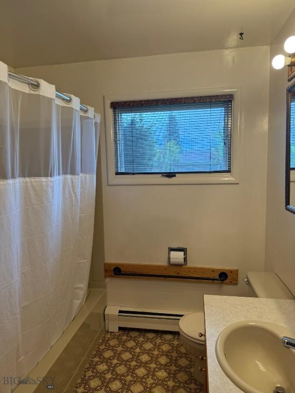 2625 George, Butte, MT 59701 - full bathroom with baseboard heating, vanity, shower / tub combo with curtain, and tile patterned flooring