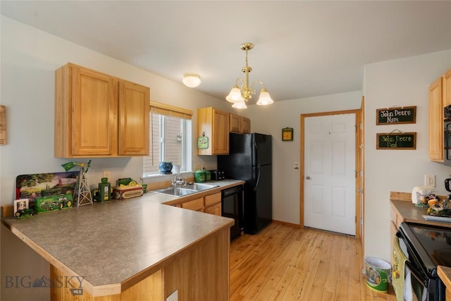 1030 N River Rock St, Belgrade, MT 59714 - kitchen featuring black appliances, light wood finished floors, a chandelier, a peninsula, and hanging light fixtures