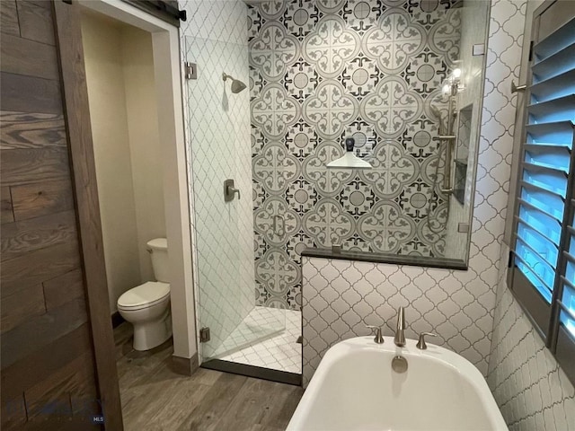 1792 Windrow Dr, Bozeman, MT 59718 - bathroom featuring wood finished floors, wallpapered walls, a bathtub, and a shower stall