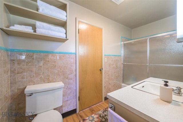 100 Nez Perce Rd, Butte, MT 59701 - full bathroom featuring tile walls, wood finished floors, wainscoting, vanity, and a shower with door