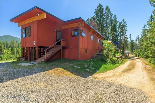 100 Nez Perce Rd, Butte, MT 59701 - view of side of home featuring a chimney, stairway, board and batten siding, and dirt driveway
