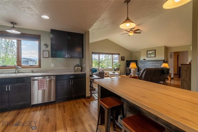 3950 Floweree, Helena, MT 59602 - kitchen featuring dishwasher, a ceiling fan, a textured ceiling, dark cabinetry, and vaulted ceiling