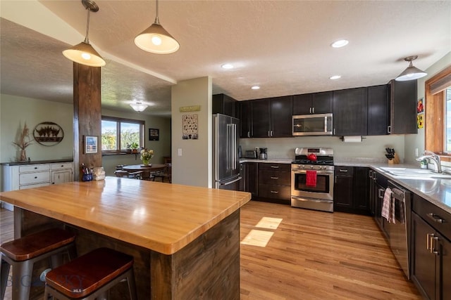 3950 Floweree, Helena, MT 59602 - kitchen featuring stainless steel appliances, wooden counters, light wood finished floors, hanging light fixtures, and a textured ceiling