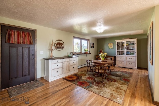3950 Floweree, Helena, MT 59602 - dining area with a textured ceiling, a baseboard heating unit, and light wood-type flooring