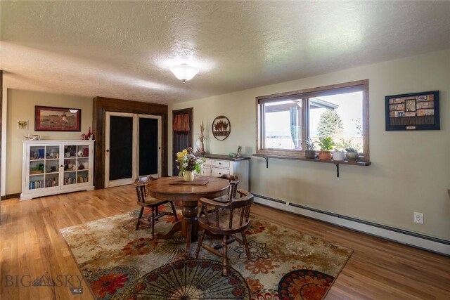 3950 Floweree, Helena, MT 59602 - dining room with baseboard heating, a textured ceiling, and light wood-style flooring
