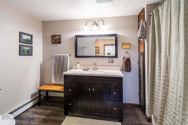 3950 Floweree, Helena, MT 59602 - bathroom featuring a baseboard radiator, wood finished floors, vanity, a textured wall, and a shower with curtain