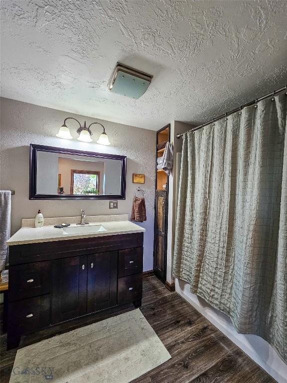 3950 Floweree, Helena, MT 59602 - bathroom with wood finished floors, vanity, a textured ceiling, and a textured wall