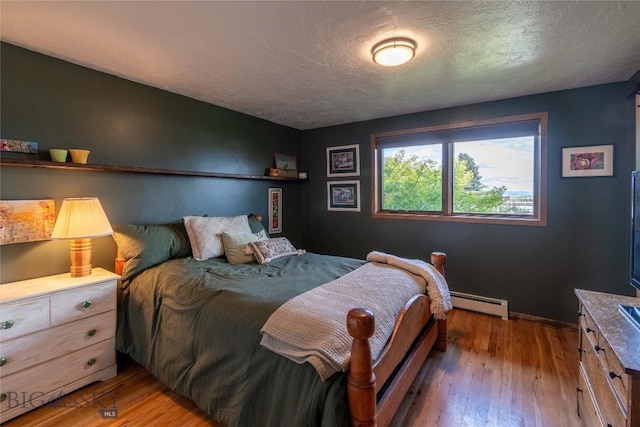 3950 Floweree, Helena, MT 59602 - bedroom with a baseboard heating unit, wood-type flooring, and a textured ceiling