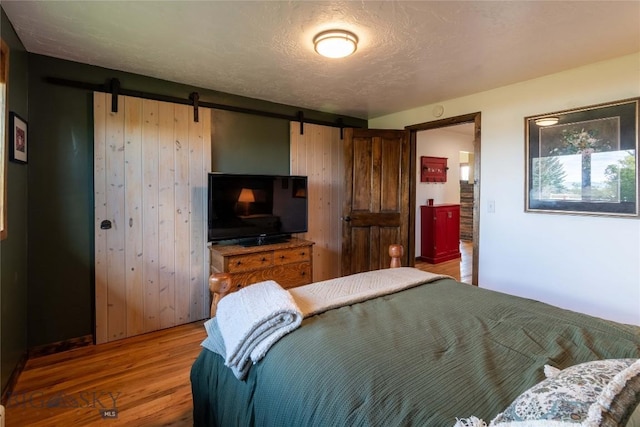 3950 Floweree, Helena, MT 59602 - bedroom featuring a barn door and wood finished floors