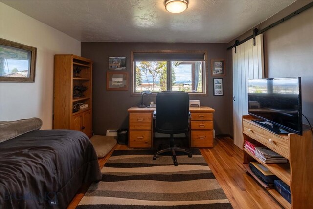 3950 Floweree, Helena, MT 59602 - bedroom with light wood finished floors, a desk, and a barn door