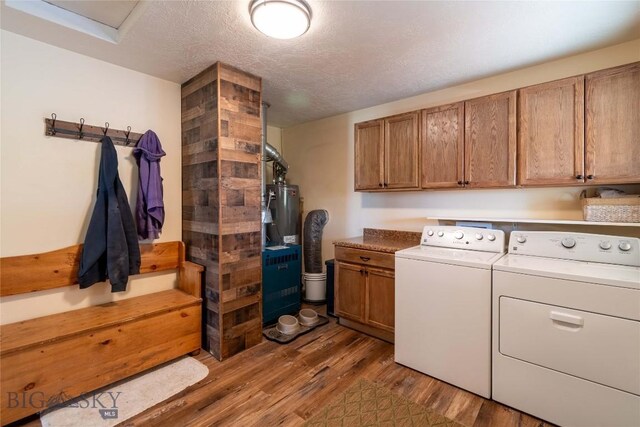 3950 Floweree, Helena, MT 59602 - laundry room featuring washing machine and clothes dryer, cabinet space, dark wood-style floors, a textured ceiling, and water heater