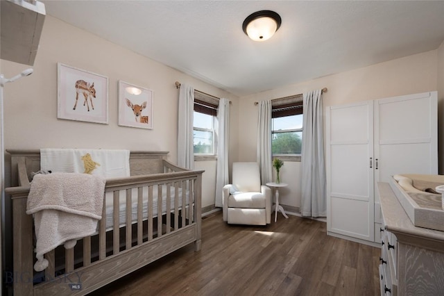 219 W Adams, Three Forks, MT 59752 - bedroom with dark wood-style floors and a crib