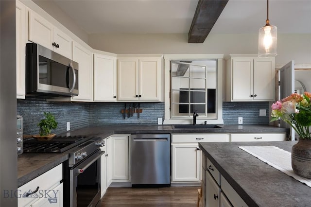 219 W Adams, Three Forks, MT 59752 - kitchen with stainless steel appliances, dark countertops, beamed ceiling, white cabinetry, and decorative backsplash