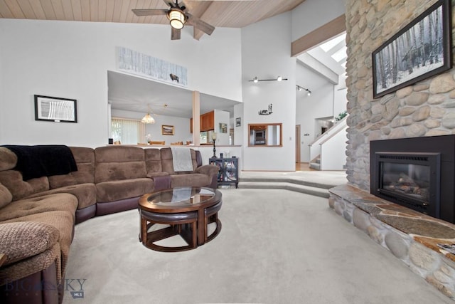 8A Gallatin Dr, Bozeman, MT 59718 - carpeted living area featuring a ceiling fan, a stone fireplace, high vaulted ceiling, wooden ceiling, and stairs