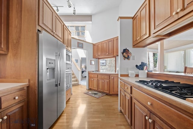8A Gallatin Dr, Bozeman, MT 59718 - kitchen with stainless steel appliances, track lighting, light wood-type flooring, light countertops, and brown cabinets