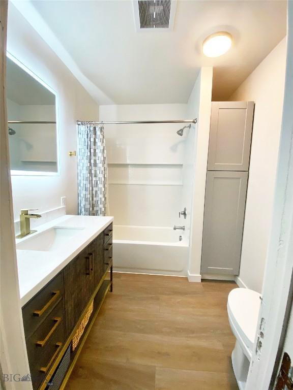 3575 Stucky Rd, Bozeman, MT 59715 - full bath featuring vanity, shower / bathtub combination with curtain, and wood finished floors