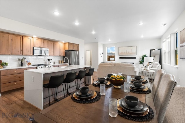 608 Mira Way Unit A, Belgrade, MT 59714 - kitchen featuring stainless steel appliances, a kitchen breakfast bar, open floor plan, light countertops, and recessed lighting
