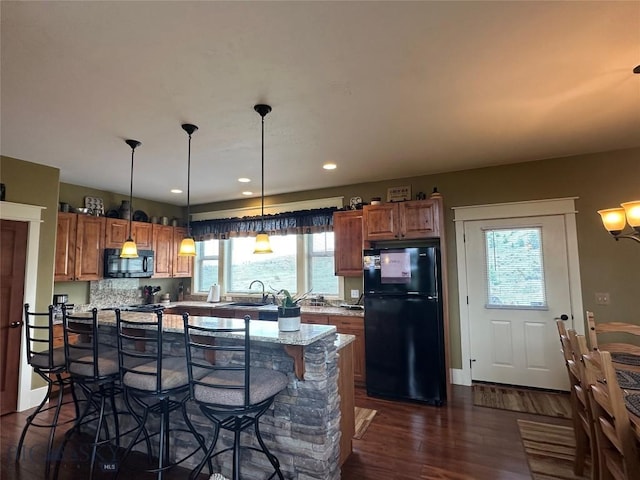 64 Mountain View Trl, White Sulphur Springs, MT 59645 - kitchen with black appliances, a kitchen bar, dark wood-style flooring, brown cabinetry, and recessed lighting
