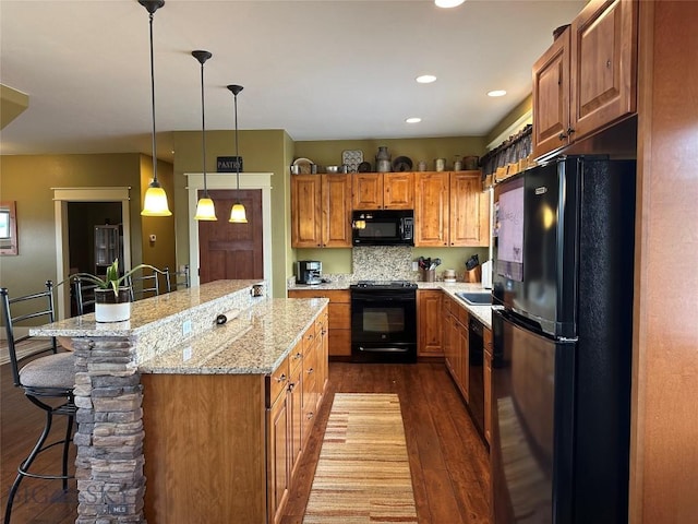 64 Mountain View Trl, White Sulphur Springs, MT 59645 - kitchen with black appliances, dark wood-style flooring, a kitchen breakfast bar, brown cabinetry, and light stone countertops