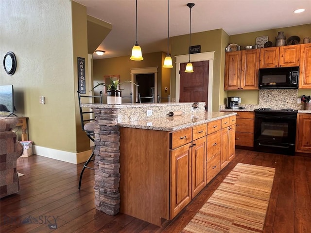 64 Mountain View Trl, White Sulphur Springs, MT 59645 - kitchen with black appliances, a breakfast bar, dark wood-style flooring, and a kitchen island with sink