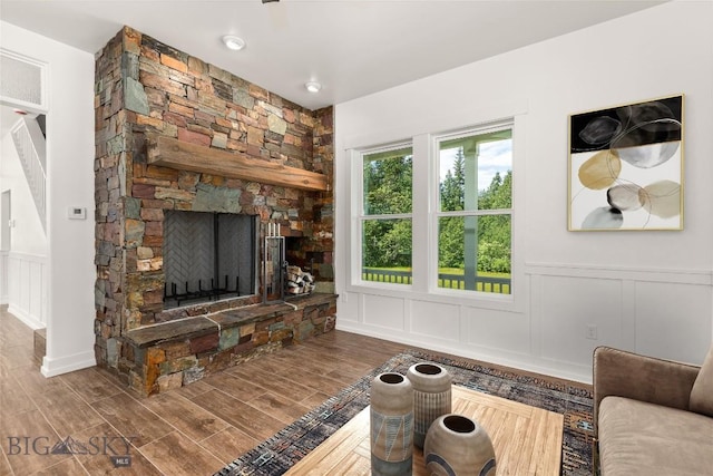 189 Blue Creek Rd, Heron, MT 59844 - living area featuring a decorative wall, wood finished floors, a fireplace, and wainscoting