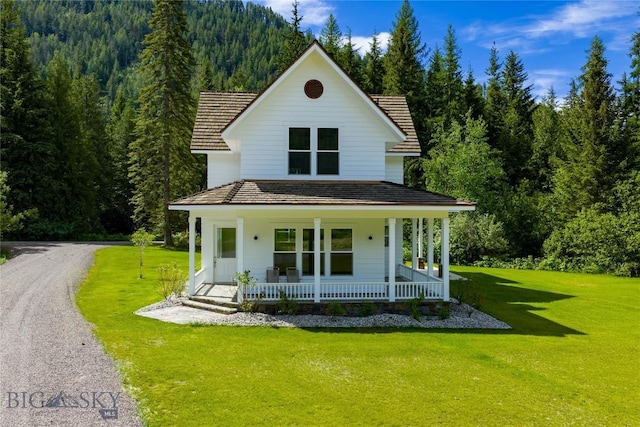 189 Blue Creek Rd, Heron, MT 59844 - country-style home with covered porch, a wooded view, and a front yard