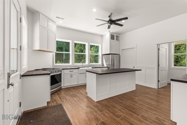 189 Blue Creek Rd, Heron, MT 59844 - kitchen with appliances with stainless steel finishes, dark countertops, white cabinetry, a kitchen island, and ceiling fan