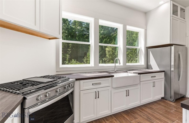 189 Blue Creek Rd, Heron, MT 59844 - kitchen with appliances with stainless steel finishes, healthy amount of natural light, white cabinetry, and wood finished floors
