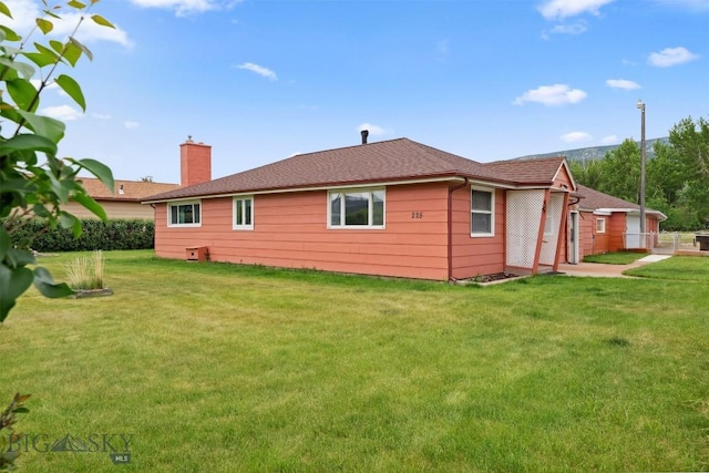 225 Mountain View Dr S, Anaconda, MT 59711 - back of house with a yard, a chimney, and roof with shingles