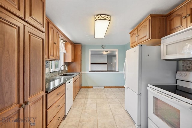 225 Mountain View Dr S, Anaconda, MT 59711 - kitchen with white appliances, dark stone countertops, brown cabinets, and backsplash