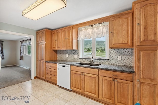225 Mountain View Dr S, Anaconda, MT 59711 - kitchen featuring dishwasher, tasteful backsplash, light carpet, brown cabinets, and dark stone counters