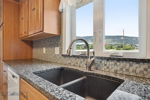225 Mountain View Dr S, Anaconda, MT 59711 - kitchen featuring white dishwasher, decorative backsplash, dark stone counters, and brown cabinetry