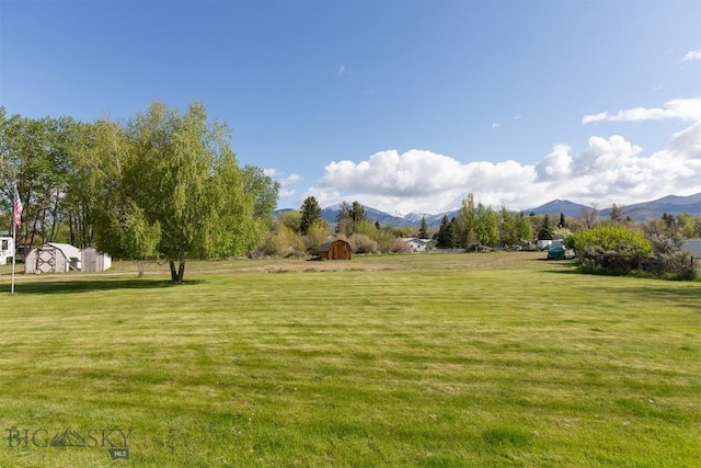 507 E Poppleton, Sheridan, MT 59749 - view of green lawn with a shed and a mountain view