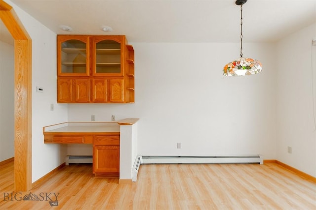 507 E Poppleton, Sheridan, MT 59749 - kitchen with a baseboard heating unit, light wood-style floors, built in desk, light countertops, and decorative light fixtures