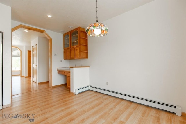 507 E Poppleton, Sheridan, MT 59749 - unfurnished dining area with a baseboard heating unit, light wood-type flooring, arched walkways, and recessed lighting