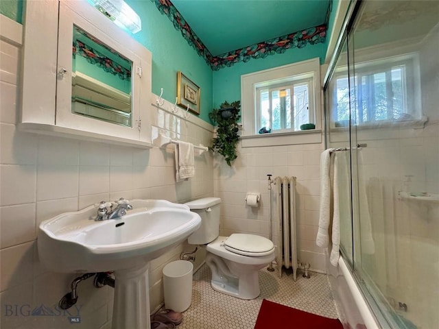 108 S 8th St, Livingston, MT 59047 - full bath featuring radiator, tile walls, tile patterned flooring, and shower / bath combination with glass door