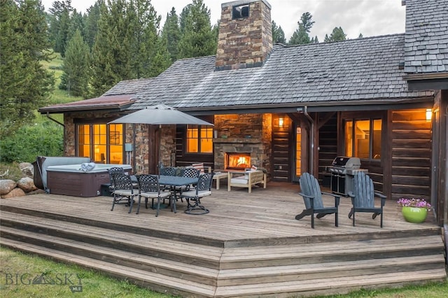 2055 Ousel Falls Rd, Big Sky, MT 59716 - rear view of house with an outdoor stone fireplace, a wooden deck, a hot tub, and a chimney