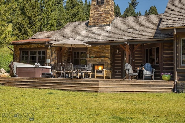 2055 Ousel Falls Rd, Big Sky, MT 59716 - back of property featuring a chimney, an outdoor stone fireplace, a lawn, and a wooden deck