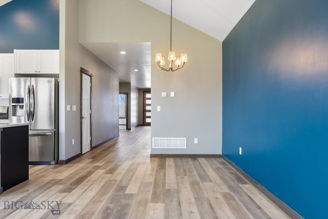 142 Albrey Trl Unit C, Bozeman, MT 59718 - unfurnished dining area featuring high vaulted ceiling, a chandelier, and light wood finished floors