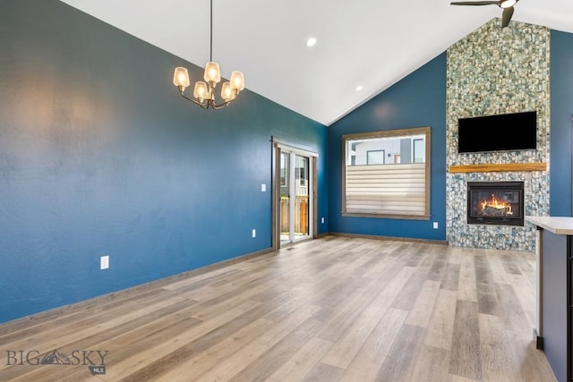 142 Albrey Trl Unit C, Bozeman, MT 59718 - unfurnished living room featuring vaulted ceiling, a stone fireplace, ceiling fan, wood finished floors, and a chandelier
