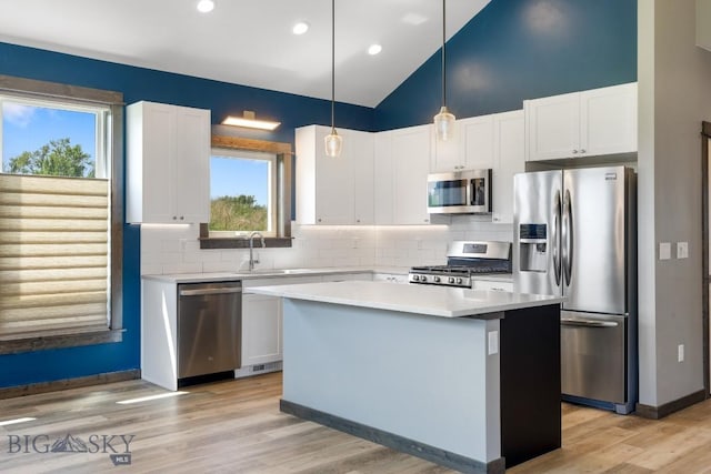 142 Albrey Trl Unit C, Bozeman, MT 59718 - kitchen with appliances with stainless steel finishes, a kitchen island, tasteful backsplash, white cabinets, and recessed lighting