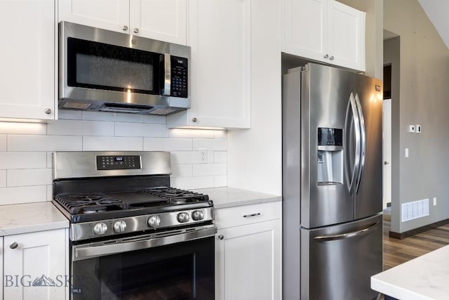 142 Albrey Trl Unit C, Bozeman, MT 59718 - kitchen with appliances with stainless steel finishes, white cabinetry, wood finished floors, and light stone countertops