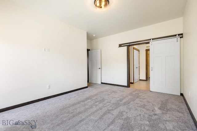 142 Albrey Trl Unit C, Bozeman, MT 59718 - unfurnished bedroom with light carpet and a barn door