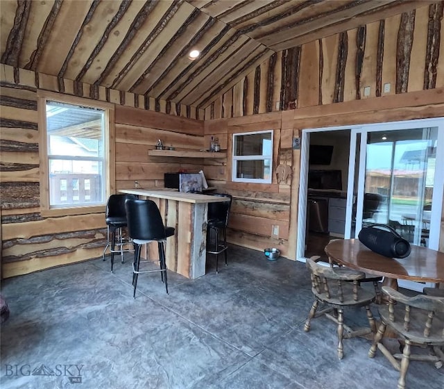 701 Barnett St, Dillon, MT 59725 - interior space with wood walls, lofted ceiling, and concrete flooring
