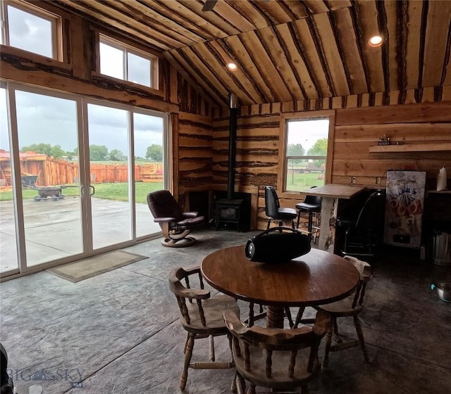 701 Barnett St, Dillon, MT 59725 - dining room featuring a wood stove, vaulted ceiling, and wood walls