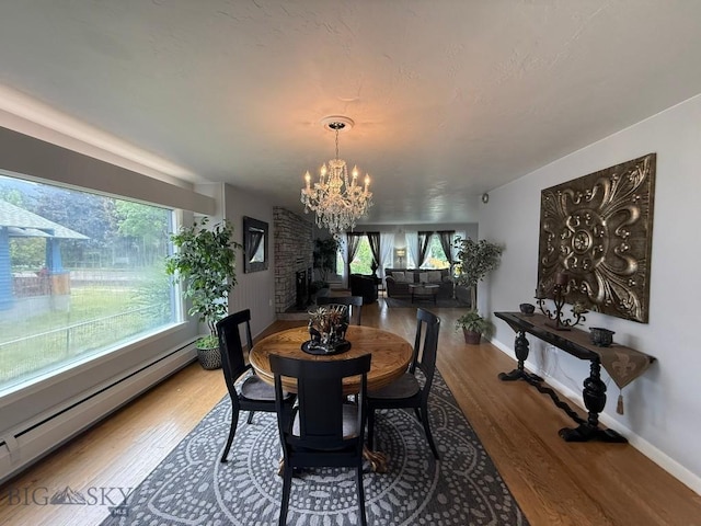2821 Edwards, Butte, MT 59701 - dining room with a baseboard heating unit, a chandelier, healthy amount of natural light, and wood finished floors