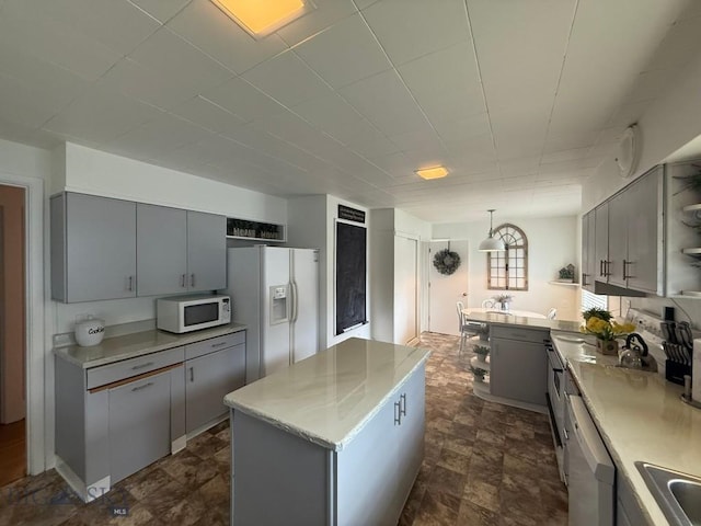 2821 Edwards, Butte, MT 59701 - kitchen featuring open shelves, white appliances, gray cabinetry, light countertops, and a center island